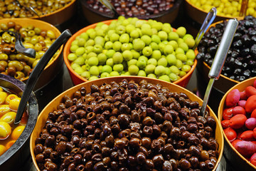 Colorful bowls of marinated olives at a food market