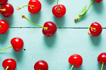 Fototapeta na wymiar sour cherry fruits on old blue wooden table background