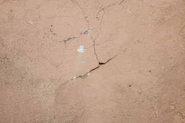 Beige stucco wall crackle surface. Light beige textured background. Grunge texture. Rough weathered backdrop