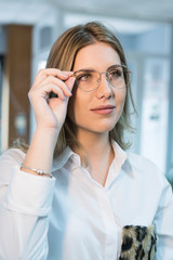 woman trying on eyeglasses in optical store