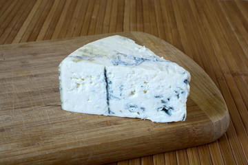 Blue cheese on a wooden board.