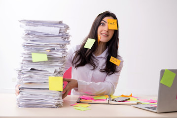Young female employee in conflicting priorities concept 