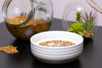 Healthy food buckwheat porridge in a plate filled with milk on a dark table with greens