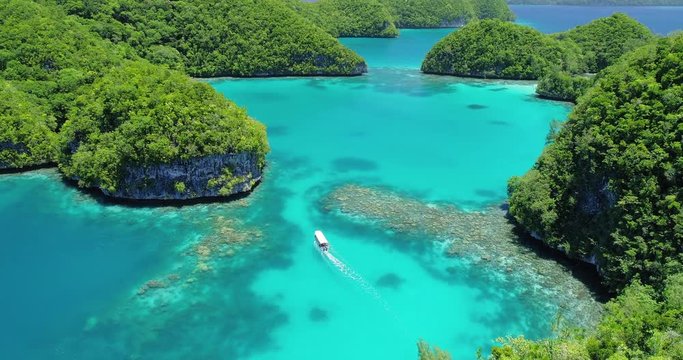 Boat travels through tropical lagoon and islands in Palau, Micronesia