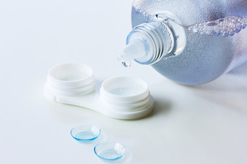 Contact lenses, case and bottle with solution on white background. Eye health and care, eyesight and vision, ophthalmology and optometry