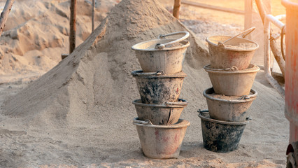Plastic buckets for transport of sand and cement at construction site