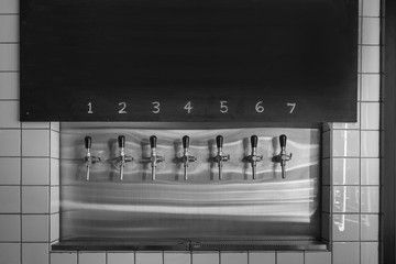 Draft beer tap faucet row in beverage bar.