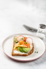 Vegatarian toast with avocado, radish and salmon. Healthy eating