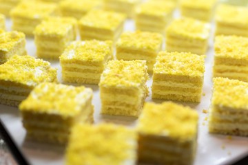 Lemon mousse cake slices or sweet dessert on a luxury gourmet buffet or in a bakers shop window