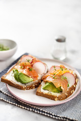 Tasty toasts with avocado, radish and salmon. Healthy eating