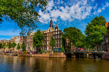 Naklejka premium urist on boat on the one of the water canals in the historical part of Amsterdam, Netherlands
