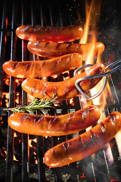 Delicious sausages sizzling over the coals on barbecue grill
