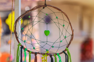 Green dream catcher with artificial heart in the middle.Made of wood and tissue.