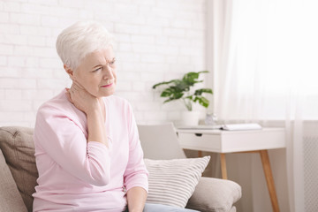 Mature woman suffering from backache at home