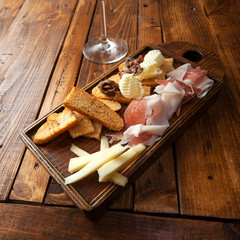 Italian food on a wooden chopping with a red wine glass