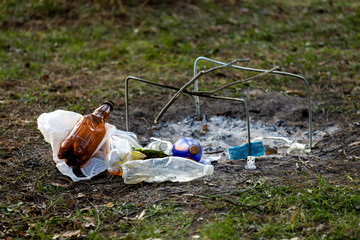 A pile of garbage in the forest park near the campfire site. environmental pollution