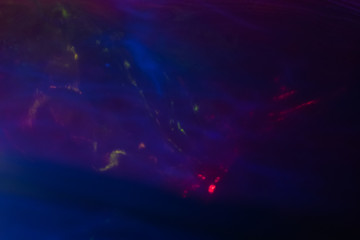 Blurred colorful neon glow. Defocused dark abstract background. Lens flare effect.