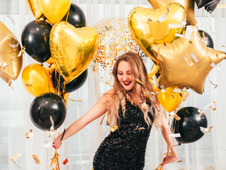 Special day. Portrait of glamorous girl with golden and black round, heart, star shaped balloons....