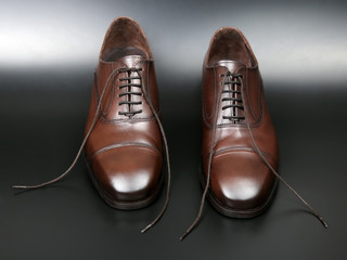 Classic men's brown Oxford shoes on dark background