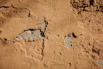Beige stucco wall crackle surface. Light beige textured background. Grunge texture. Rough weathered backdrop.