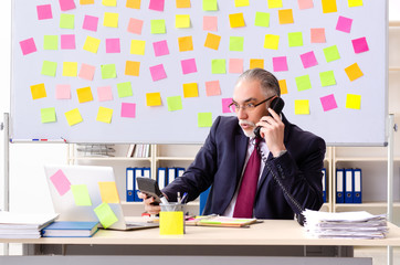 Aged man employee in conflicting priorities concept 