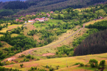 Spring is coming... Amazing spring view with a little village in Rhodopi Mountains, Bulgaria. Magnificent landscape, green fields, small houses.