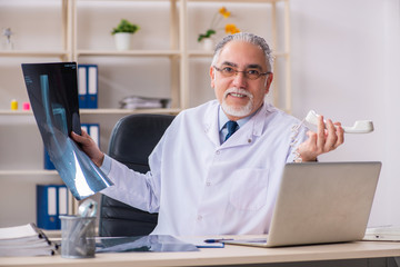Aged male doctor radiologist in the clinic 