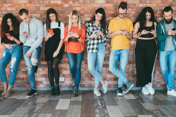 Always connected. Social networking. Group of millennials with smartphones surfing, chatting....