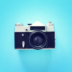 Top view of old photo camera over blue background