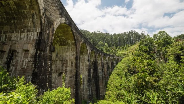 The nine arch bridge with train in Sri Lanka is a famous landmark and touristic spot to visit. 4K time-lapse while clouds are rushing by on a tropical day