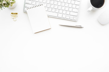 White minimal office desk table with computer keyboard, mouse and supplies. Top view with copy space, flat lay.