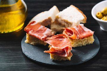 delicious Spanish potato omelette top with serrano ham, and olives