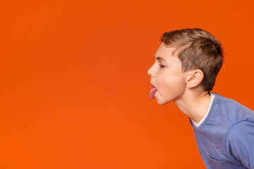 Little boy teasing someone, showing tongue and making face