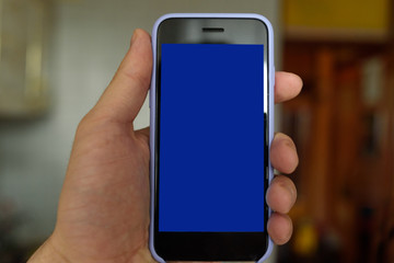 Male hand with a smartphone. Black blank screen. Home background