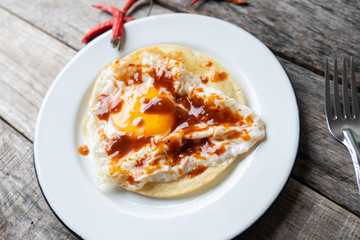 Fried egg with tortilla and hot sauce 