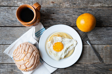 Mexican breakfast with egg, orange, sweet bread and coffee