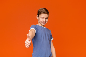 Cute teen boy showing thumb up gesture