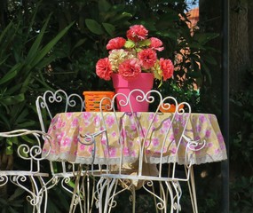 old table in the middle of the courtyard with pink flowers
