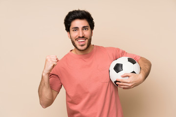 Handsome man holding a soccer ball