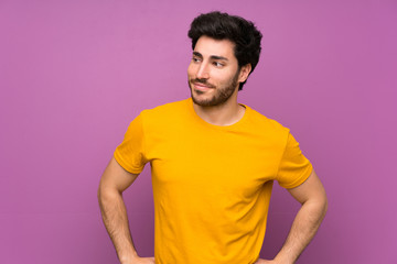 Obraz premium Handsome over isolated purple wall making doubts gesture looking side