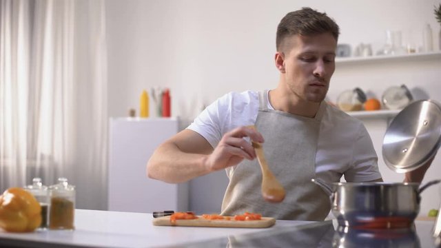 Young Man Tasting Cooked Food With Disgusted Face Expression, Funny Grimacing