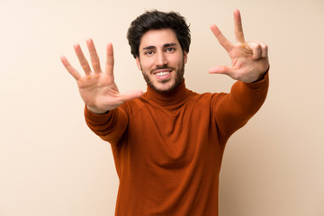Fototapeta premium Handsome over isolated wall counting eight with fingers