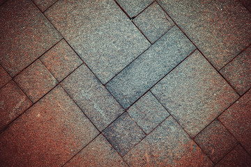 The sidewalk road made of natural stone is lined with mosaics of different colors