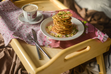 tasty breakfast in bed from eastern pancakes and Masala tea, served on the wood folding breakfast table