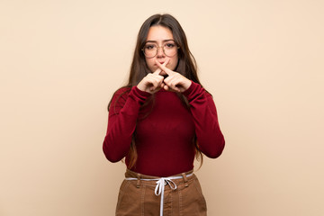 Teenager girl with glasses showing a sign of silence gesture