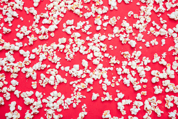 Pop corn scattered on red color background, full frame, top view