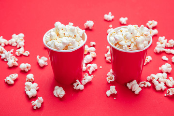 Pop corn in red paper cups on red color background