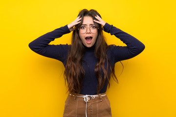 Teenager girl over isolated yellow wall with surprise expression