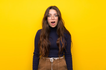 Teenager girl over isolated yellow wall with surprise facial expression