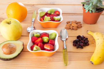 Obraz na płótnie Canvas Strawberries, banana, apple, kiwi and orange juice with some dried fruit for a perfect break